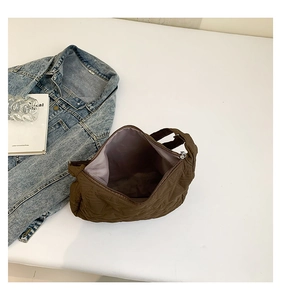 Detailed top view of brown star-quilted tote bag featuring purple lining and zipper closure