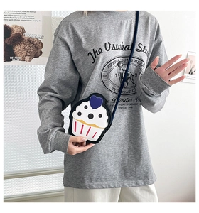 Creative cupcake shaped crossbody bag worn by a model in a casual grey sweatshirt