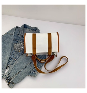 Detail of canvas tote bag with brown fabric straps and contrast edge stitching