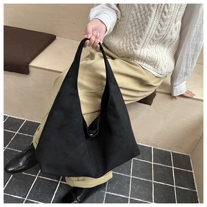 Chic black faux suede tote bag displayed on steps, showing vintage matte texture and style