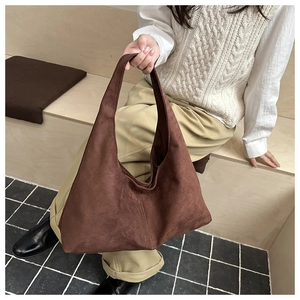 Detail of vintage matte brown shoulder bag showing soft suede texture and minimalist design