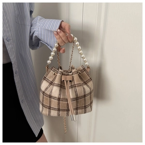 Detailed shot of retro plaid bucket bag with pearl handle and metal chain strap