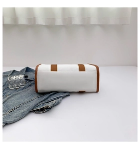 Detailed bottom view of canvas tote bag showing brown leather trim and stitching