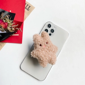Detail of cute beige plush bunny phone grip holder showing soft curly texture on white phone
