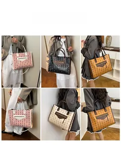 Detail view of large tote bags in four colors with vintage monogram patterns and straps