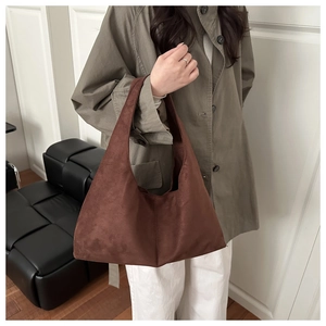 Detailed shoulder view of a large brown suede tote bag worn for a minimalist commute