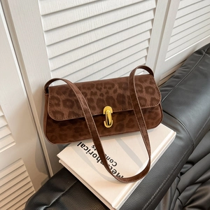 Vintage leopard print shoulder bag with gold clasp shown on a bench with a book