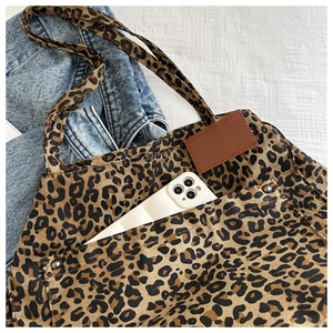Detail of leopard print canvas tote bag featuring an external pocket and large capacity