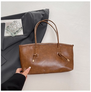Détail du sac cabas marron avec poignée nouée et texture en similicuir haut de gamme
