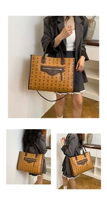 Detailed view of monogram print tote bag featuring sturdy handles and front zip pocket