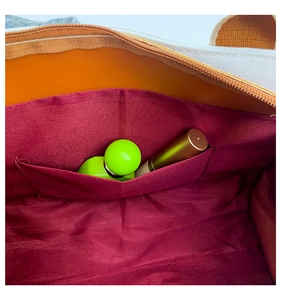 Close-up of bag interior with deep burgundy lining and functional inner pocket detail