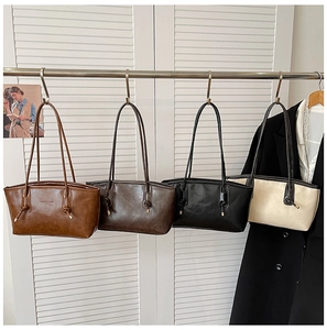 Close-up of minimalist faux leather tote bag with unique knot detail on the strap