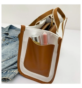 Detail view of canvas tote bag side pocket with lipstick showing storage capacity