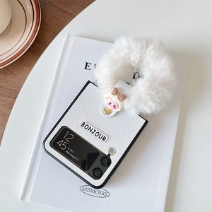 White leather-textured Samsung Galaxy Z Flip case with plush ball and cartoon charm