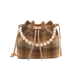 Brown plaid bucket bag with pearl handle and golden chain strap on white background