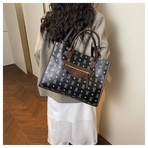 Back view of a large cartoon bear tote bag with brown leather trim on a female model