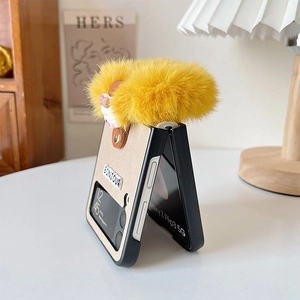 Close-up of Galaxy Z Flip case with yellow faux fur ball and Bonjour embroidery detail