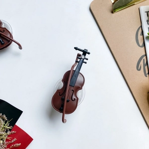 Macro detail of violin-shaped foldable phone socket holder on artistic desk setup