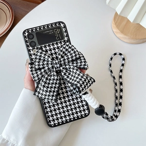 Detail of Galaxy Z Flip case featuring black and white houndstooth pattern and a large bow