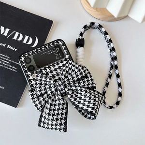 Detail of Galaxy Z Flip case with black and white houndstooth bow and long strap