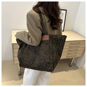 Detail of leopard print canvas tote bag with large pocket and leather trim details