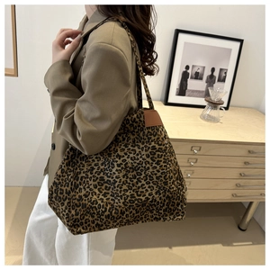 Detailed view of leopard print tote bag styled with a professional urban outfit