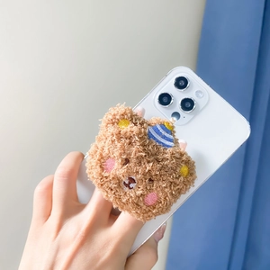 Close-up of a cute plush teddy bear phone grip with a blue striped hat and soft fur