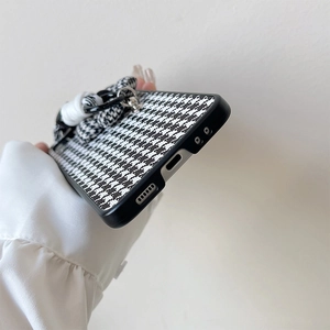 Detail of houndstooth phone case with thick lanyard and precise port cutouts