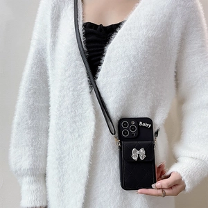 Detail of black quilted leather phone case with silver bow card holder and crossbody strap