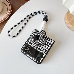 Detail of Galaxy Z Flip case with black and white houndstooth pattern and flower strap