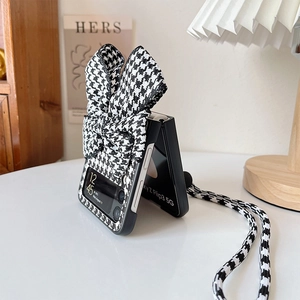 Detail of black and white houndstooth phone case for Samsung Z Flip with large bow and lanyard