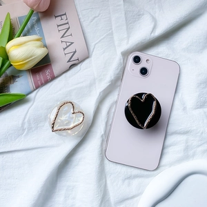 Marble texture heart-shaped phone grip with gold metal edge on pink smartphone