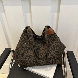 Large leopard print canvas tote bag with metal studs and adjustable shoulder strap