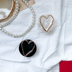 Close-up of marble pattern phone socket with gold heart hollow design on fabric
