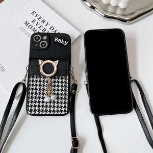 Detail of black crossbody iPhone case featuring houndstooth card slot and cat-ear ring