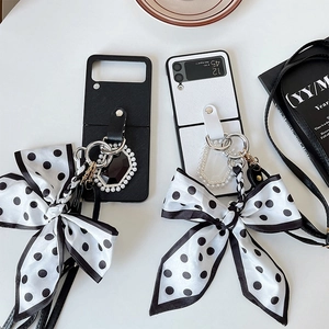 Détail de la coque Galaxy Z Flip avec grand nœud à pois et anneau orné de perles