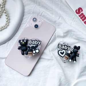 3D heart-shaped phone grip with black bear and rabbit decor on pink phone case