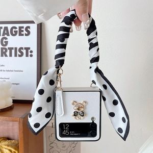 Detail view of white leather Z Flip case featuring a diamond bear and silk ribbon strap