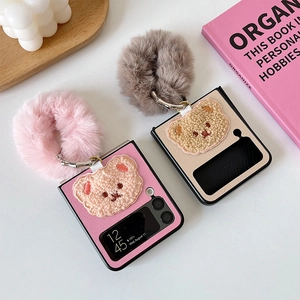 Detail of pink plush bear embroidery and fuzzy ring strap on a Galaxy Z Flip case