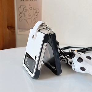 Détail de la coque Galaxy Z Flip3 montrant le cuir blanc et la bandoulière à pois
