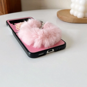 Detailed view of pink leather phone case with soft plush pompom and black shockproof bumper