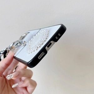 Détail de la coque pliable avec support cœur en perles et sangle en chaîne métallique