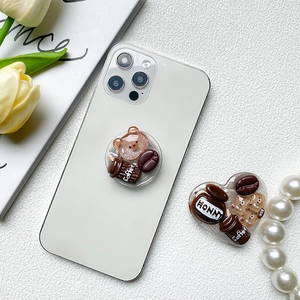 Detalle de griptoks de corazón y redondos para móvil con dijes de osos y tazas de café