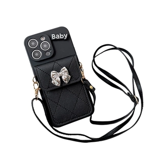 Black iPhone case with leather wallet, silver bow, and adjustable crossbody strap