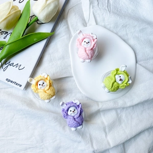 Macro detail of cute 3D resin animal phone stands in pastel cabbage hoodie designs