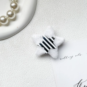 Detail of plush star phone grip with black and white stripe inlay on white texture