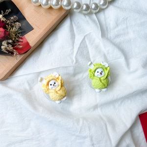 Close-up of cute rabbit phone grips in vegetable costumes on a stylish white fabric