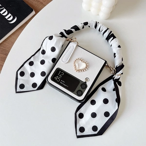 Detail of Galaxy Z Flip case with pearl heart decor and black polka dot silk handle strap