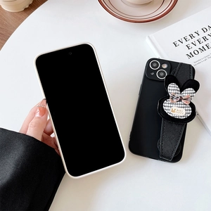 Detail of black silicone phone case with houndstooth rabbit wrist strap and luxury grip