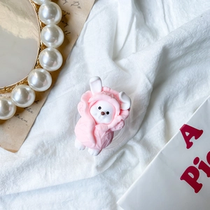 Detail of cute rabbit phone grip with pink cabbage hat on soft white fabric background